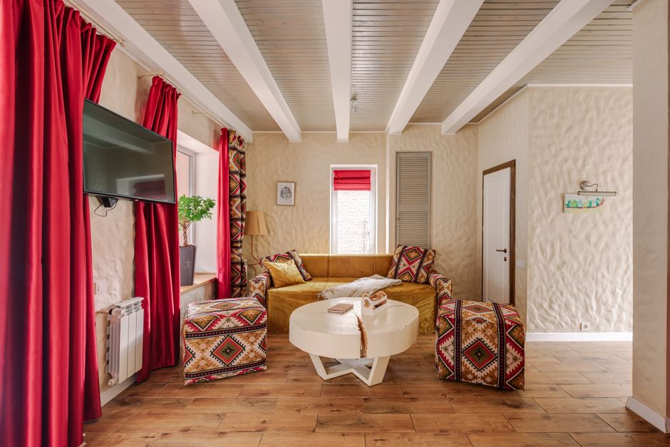 Modern living room featuring a yellow sofa, vibrant curtains, and ethnic-patterned armchairs.