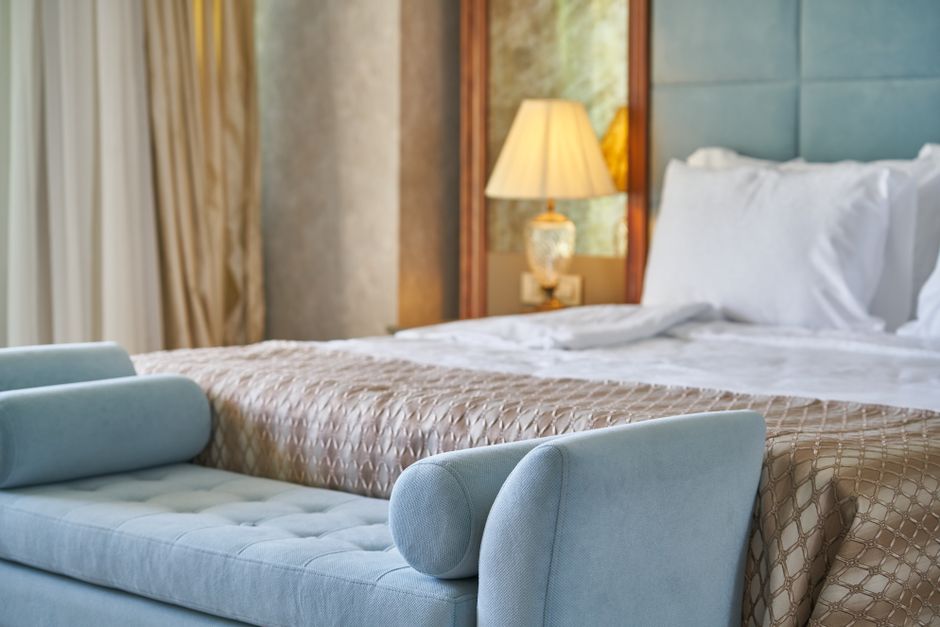 Elegant bedroom interior featuring plush bed and seating with cozy ambiance lighting.
