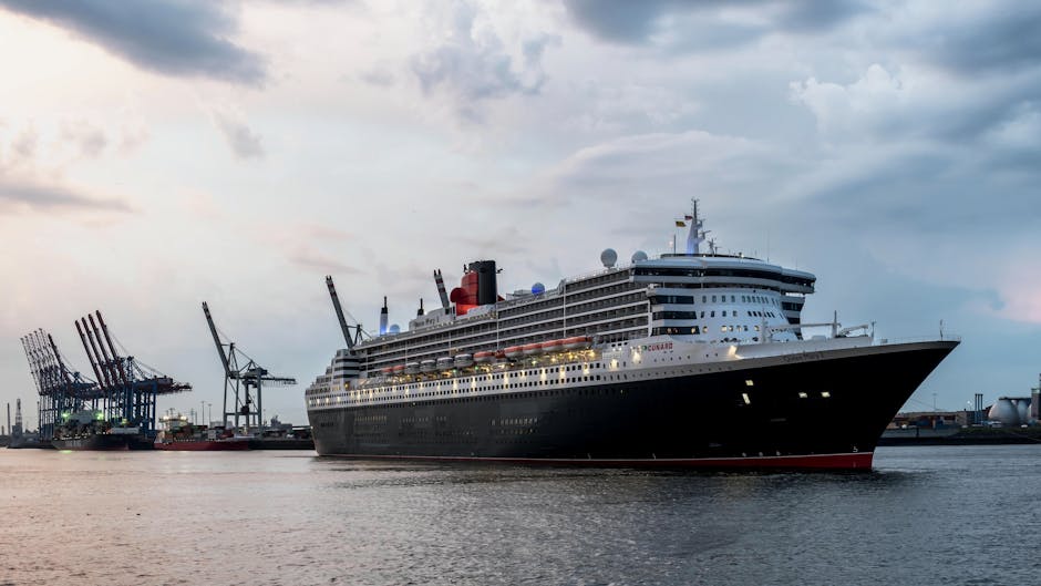 Queen Mary 2 at Hamburg Harbor surrounded by cranes and calm waters under a morning sky.