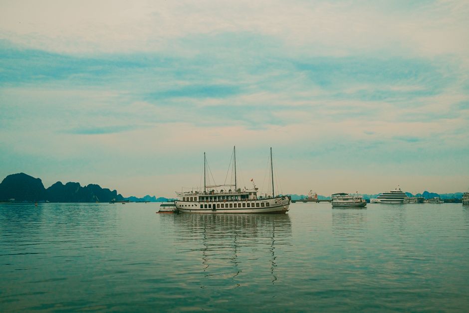 Peaceful scene of a cruise ship on Halong Bay with scenic limestone karsts.
