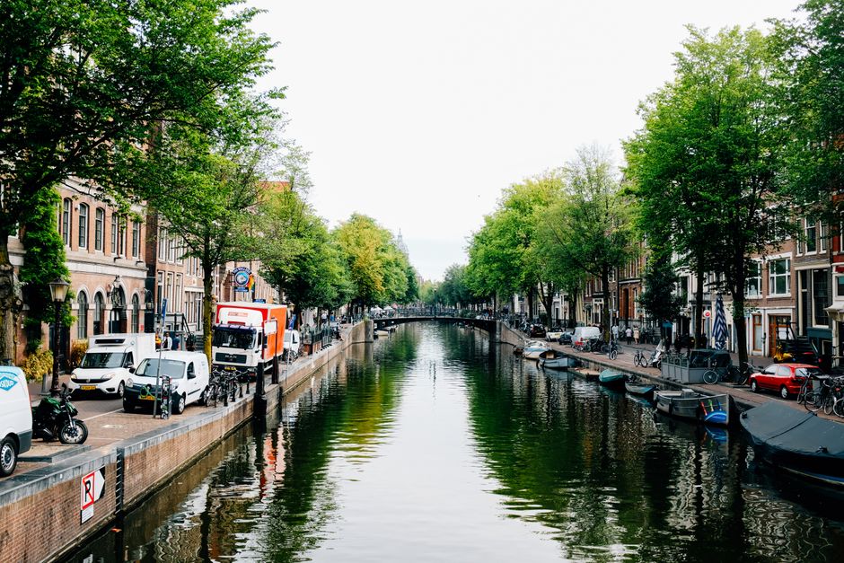 Picturesque view of old stone houses located on city canal shore on clear spring day