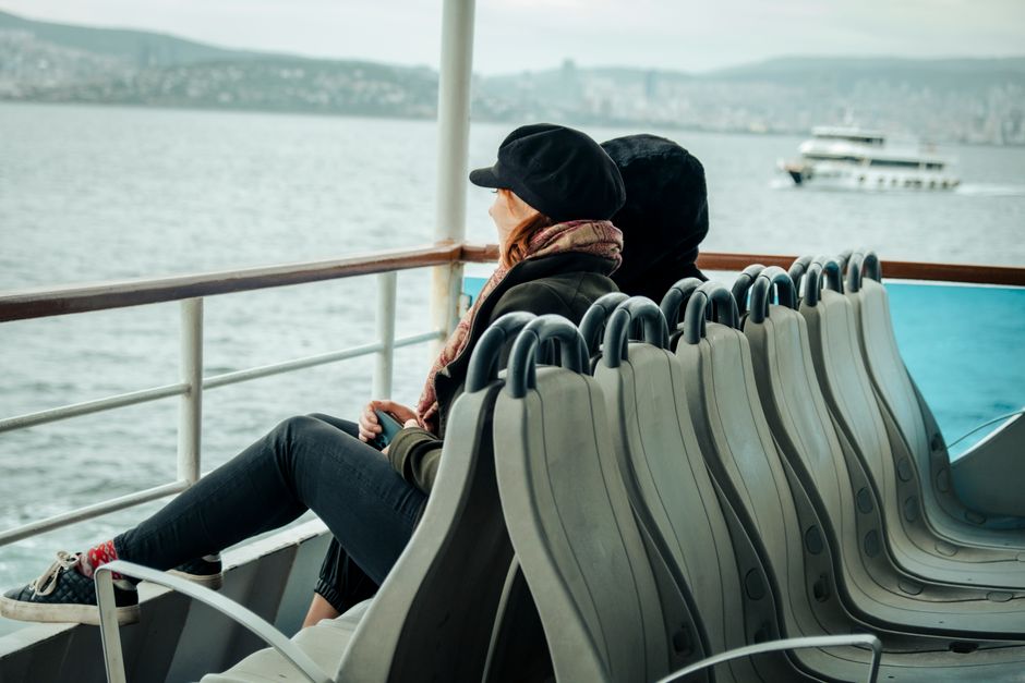 A couple sitting on a ferry enjoying the serene sea view. Ideal for travel and lifestyle themes.