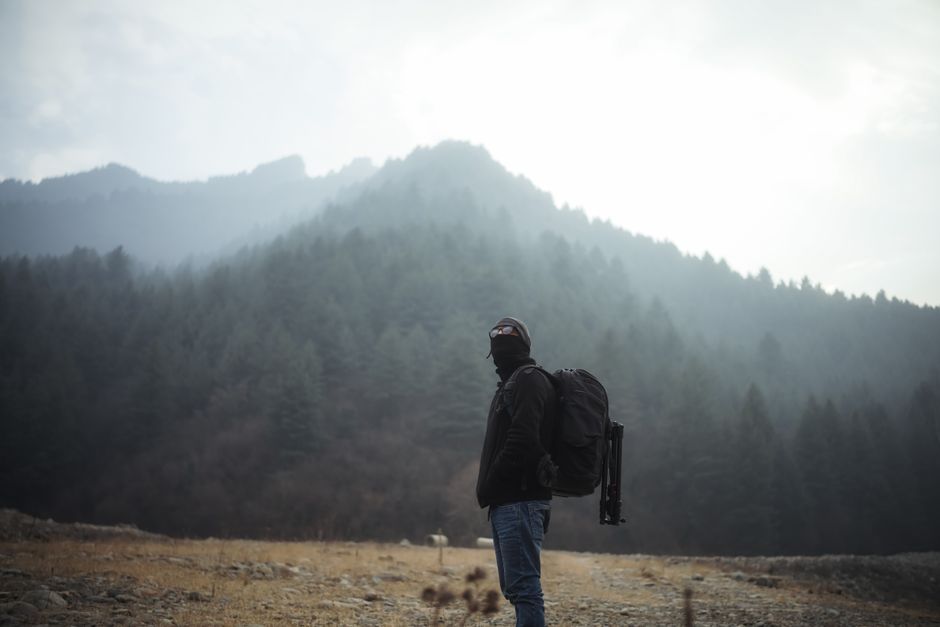 A lone backpacker explores a misty forest in the mountains, capturing the essence of solitude and adventure.