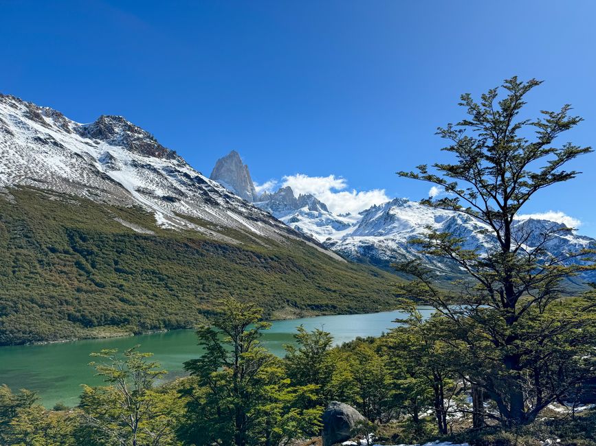 Scenic view of snow-capped mountains and lush valley with clear river in Santa Cruz, Argentina.