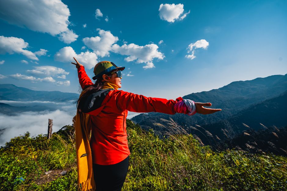 A woman enjoys a breathtaking mountain view, embracing freedom and nature.