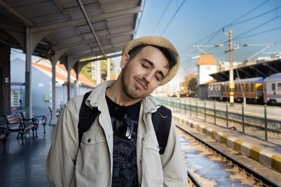 Young man in casual attire at Balıkesir train station, embracing travel vibes.