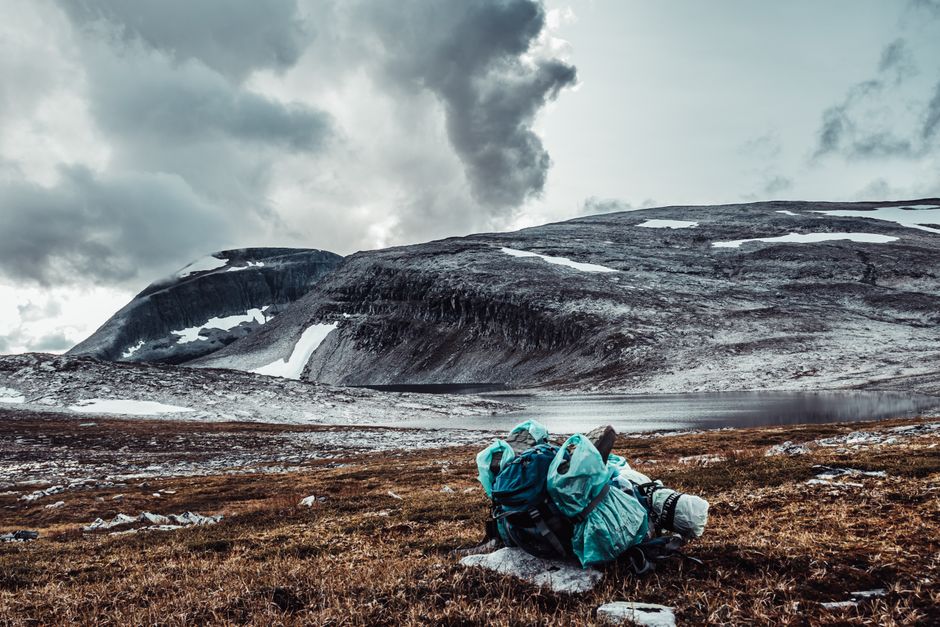A scenic snowy mountain landscape with backpacking equipment on a wintery hike.