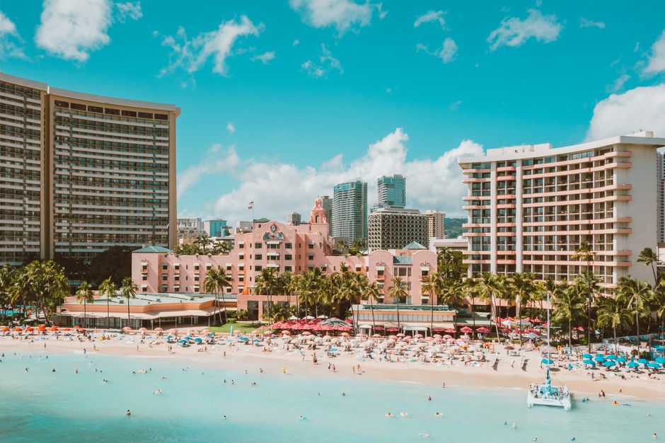 A stunning view of Waikiki Beach with vibrant city skyscrapers and lush palm trees.