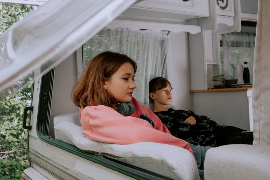 Two friends lounging inside a mobile home, enjoying a serene moment together.